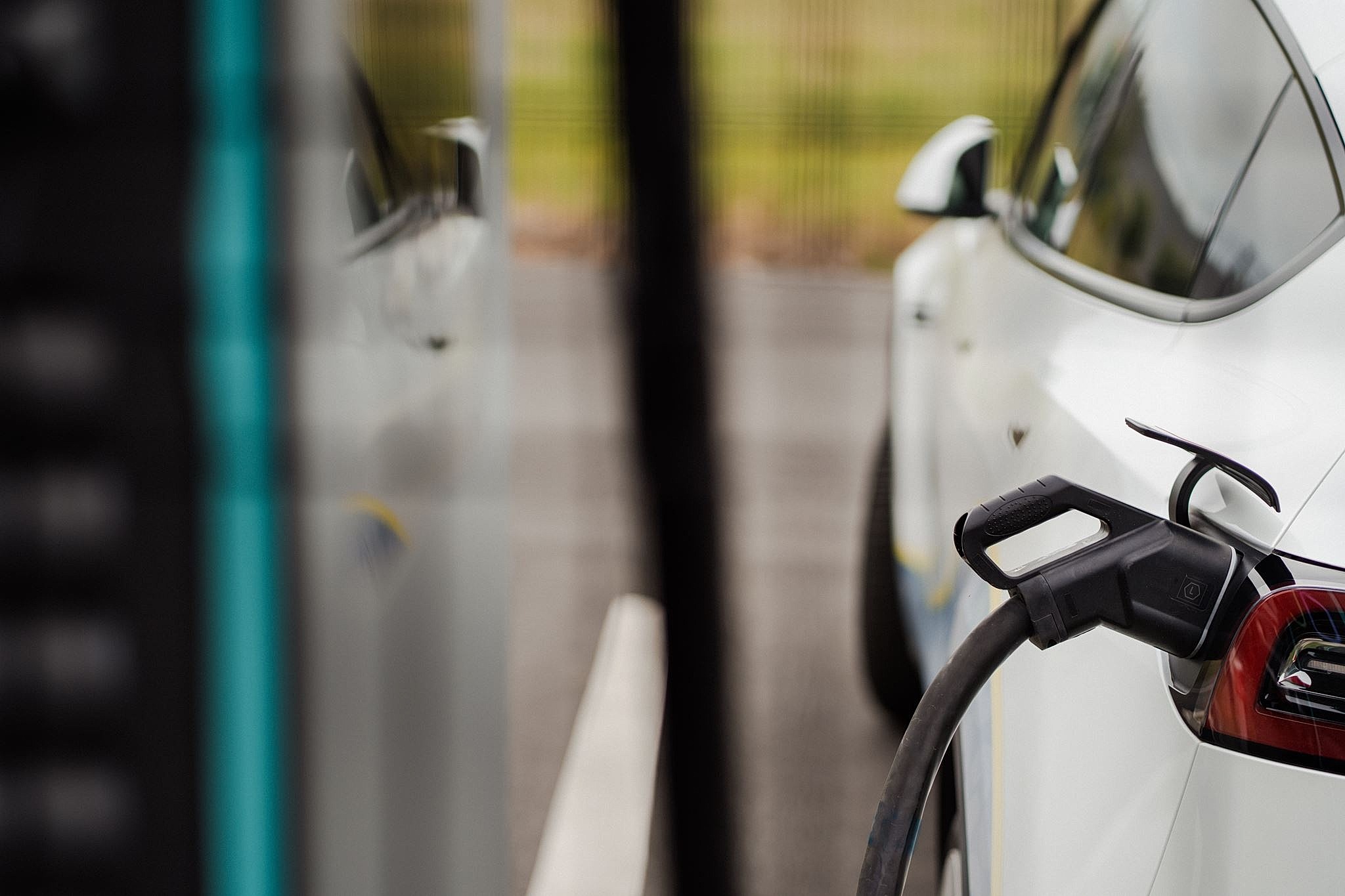 Laadkabel aangesloten op een witte elektrische wagen aan een laadstation