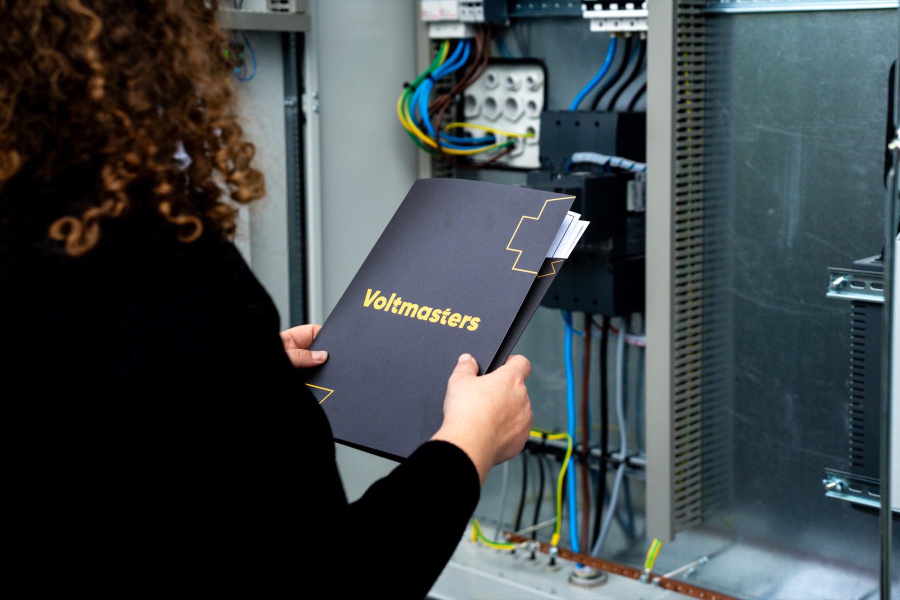 Commissioning on site: reviewing the Voltmasters documentation at the electrical cabinet